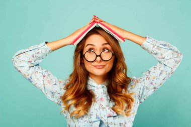 Güzel genç öğrenci kitap üstünde onun baş ve giyen gla