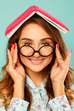 Güzel genç öğrenci kitap üstünde onun baş ve giyen gla