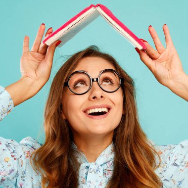 Güzel genç öğrenci kitap üstünde onun baş ve giyen gla