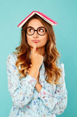 Güzel genç öğrenci kitap üstünde onun baş ve giyen gla