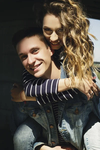 Genç güzel çift giyen kot giysiler ışığında moda.