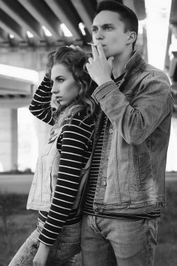 Genç güzel çift giyen kot giysiler ışığında moda.