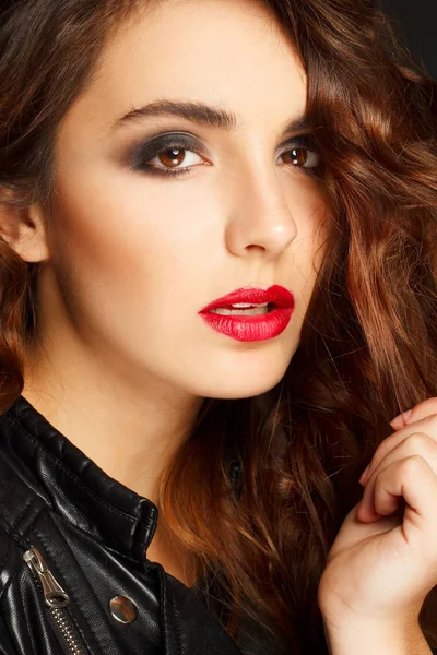 Siyah deri ceket gri b üzerinde poz güzel genç kadın