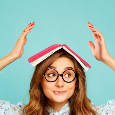 Güzel genç öğrenci kitap üstünde onun baş ve giyen gla