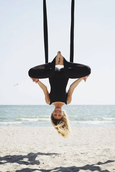 Young beautiful brunette woman doing fly yoga. Sitting in hammoc — Stock Photo, Image