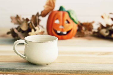 Ahşap arka plan üzerinde bulanık pumpkie resmi te fincan ile