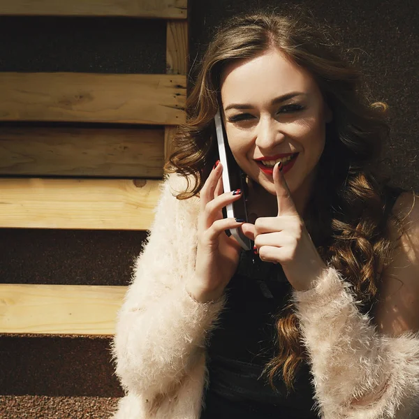 Retrato de una joven atractiva hablando por teléfono y mostrando un gesto de silencio — Foto de Stock