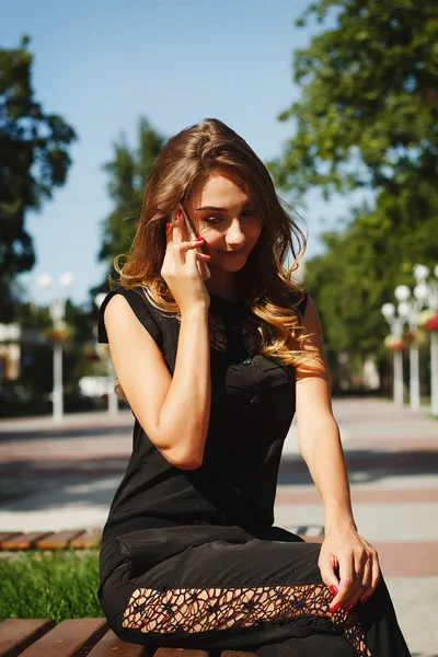 Retrato de una hermosa joven hablando por teléfono inteligente — Foto de Stock