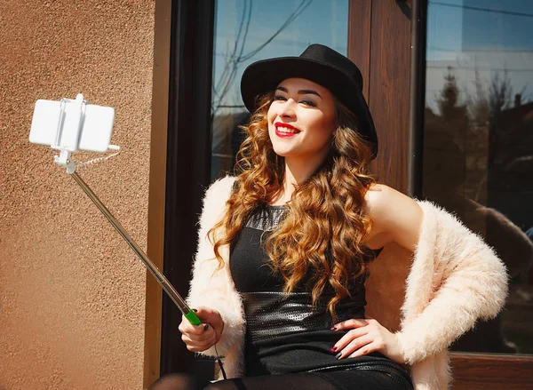 Retrato de una hermosa mujer joven haciendo selfie en el teléfono inteligente — Foto de Stock