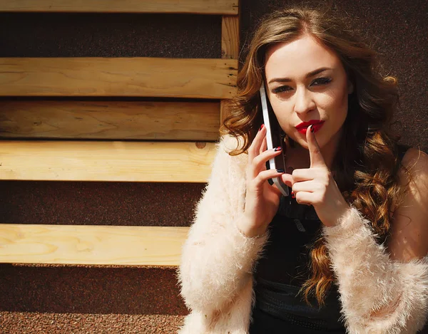 Retrato de una hermosa joven hablando por teléfono inteligente — Foto de Stock