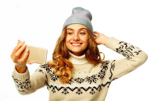 Giovane donna felice in maglione caldo prendendo il suo selfie su bianco — Foto Stock