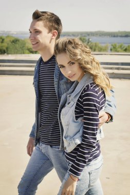 Genç güzel çift giyen kot giysiler ışığında moda.