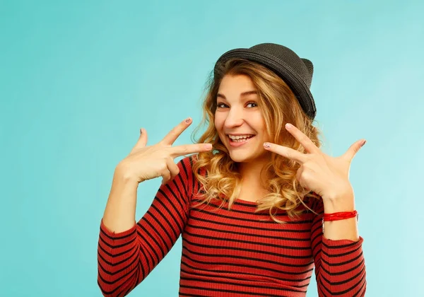 Fröhliche junge Frau lacht laut über blauen Hintergrund — Stockfoto