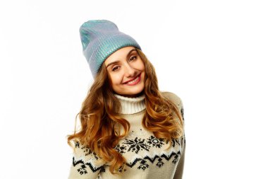 Beyaz arka plan üzerinde sıcak kazaklı genç mutlu kadın