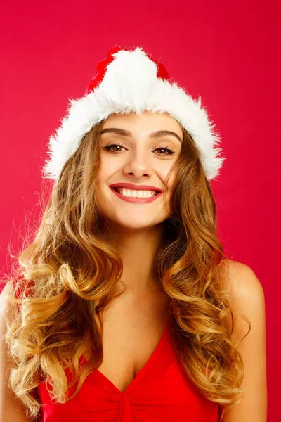 Young attractive Santa girl in red dress over red background — Stock Photo, Image