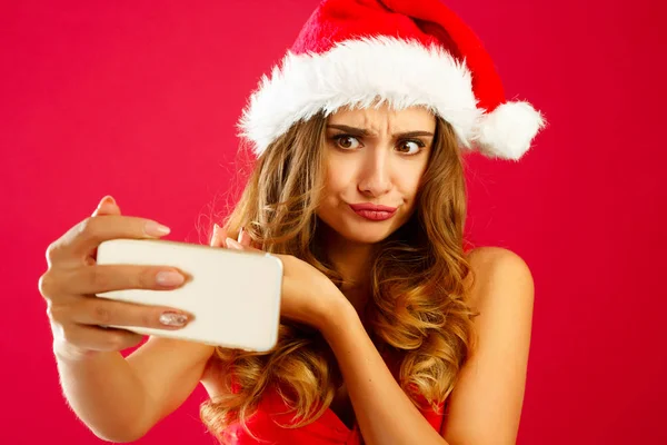 Young pretty Santa woman in red dress taking her selfie over red — Stock Photo, Image