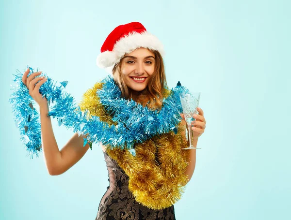 Junges attraktives Weihnachtsmädchen in rotem Kleid auf blauem Hintergrund — Stockfoto