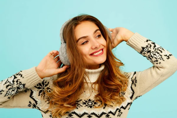 Hübsche junge Frau im warmen Pullover vor blauem Hintergrund — Stockfoto