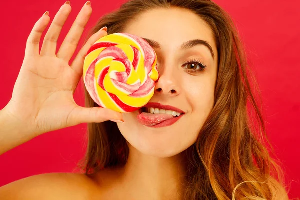 Portrait d'une jolie fille heureuse tenant des bonbons sucrés sur bac rouge — Photo