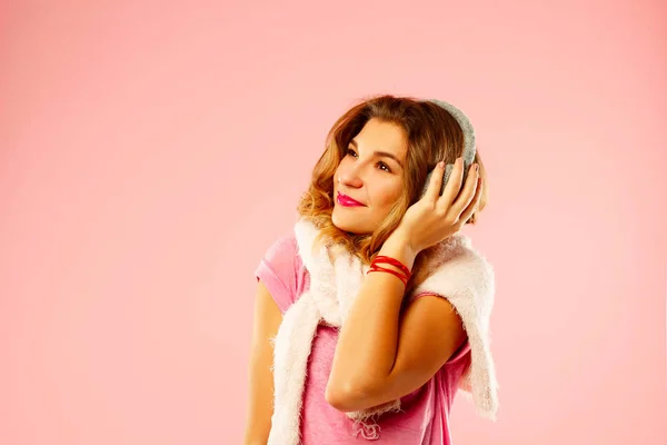 Fröhliche junge Frau im Winterpullover mit gestrickten Kopfhörern über — Stockfoto