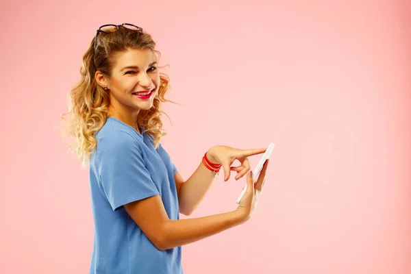 Porträt einer schönen jungen Frau mit Tablet über rosa Backgr — Stockfoto