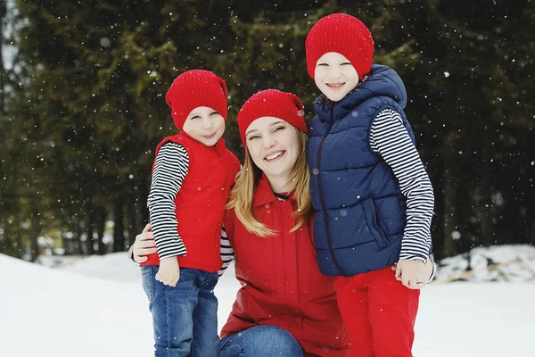 Mutter und ihre beiden Söhne vergnügen sich im Winter im Schnee — Stockfoto