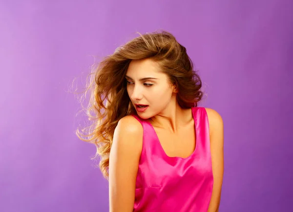 Beautiful young woman posing in studio over violet background. F — Stock Photo, Image