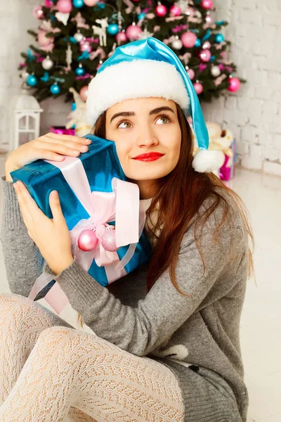 Young happy woman in  warm sweather near new year tree with pres — Stock Photo, Image