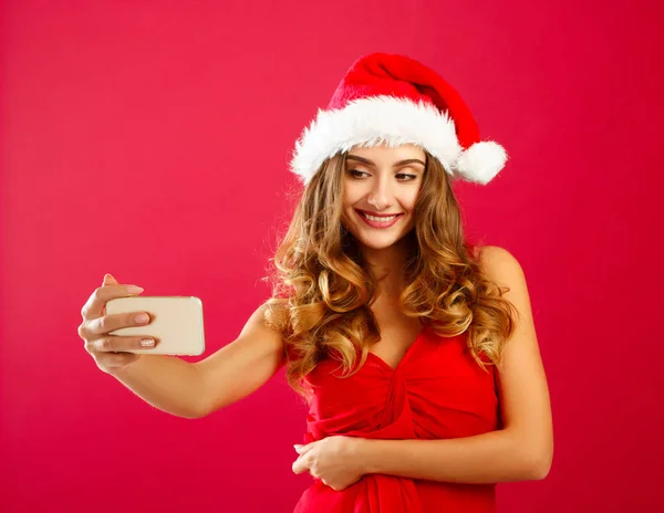 Jovem feliz Santa mulher em vestido vermelho levando sua selfie sobre vermelho — Fotografia de Stock