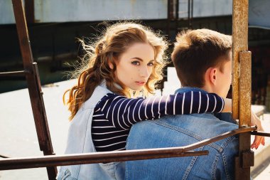 Genç güzel çift giyen kot giysiler ışığında moda.