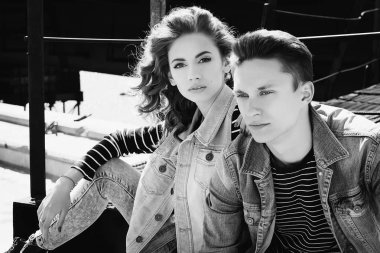 Genç güzel çift giyen kot giysiler ışığında moda.