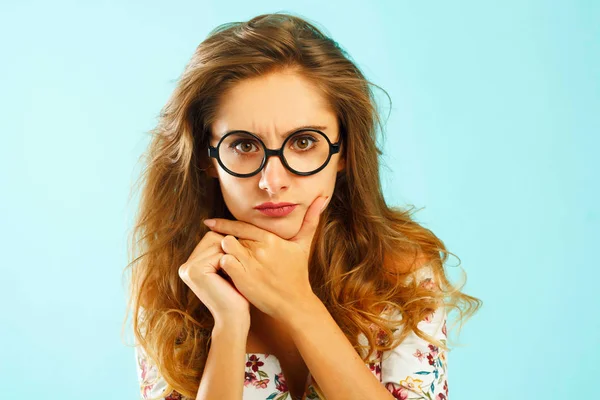 Schöne attraktive Frau in runden Gläsern vor blauem Hintergrund — Stockfoto