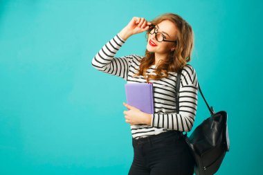 Üzerinde mavi b gözlüklü kitap ile güzel gülen kız öğrenci