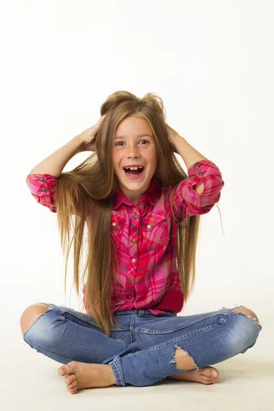 Jonge mooie kleine meisje glimlacht houdt haar haren over witte b — Stockfoto