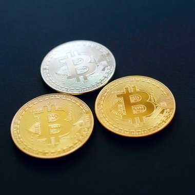 Siyah arka plan üzerinde üç altın bitcoin resmi. Dijital Pzt
