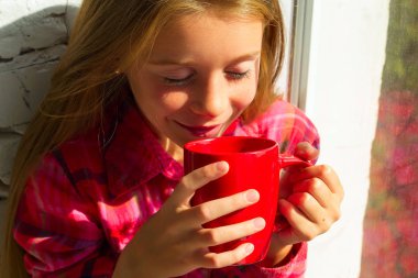 Küçük güzel gülen kız Kupası elinde içki ile portresi