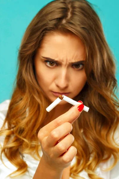 Junge attraktive Frau mit kaputter Zigarette in der Hand — Stockfoto