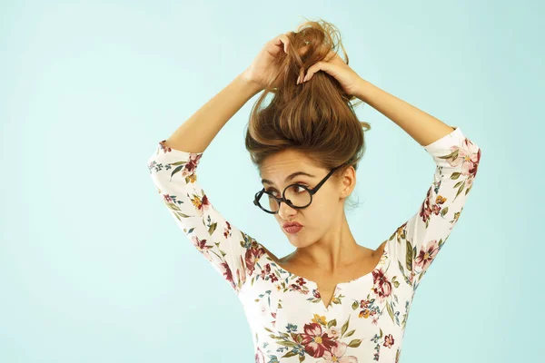 Grappige mooie jonge vrouw in ronde bril holding haar haren omhoog ov — Stockfoto