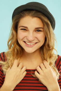 Güzel genç mutlu kadın stüdyoda mavi backgrou üzerinde gülümseyen