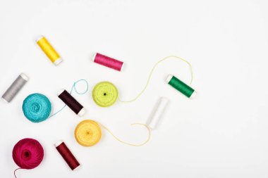 Beautiful multi-colored threads for knitting and sewing on a white background. Top view.