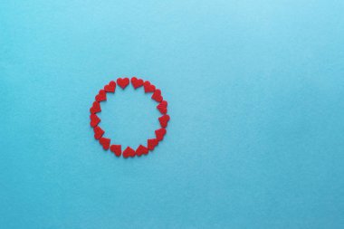 Sevgililer Günü. Mavi yüzeyde daire şeklinde kırmızı küçük kalpler. Üst görünüm.