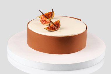 Beyaz bir tabakta incir dilimleriyle süslenmiş güzel bir çikolata kremalı tatlı. Beyaz arka plan. Yakın plan..