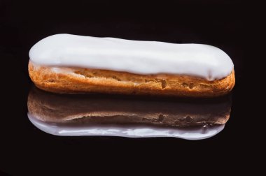 Beyaz kremalı Choux keki. Siyah arka plan. Yakın plan..