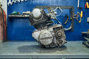 Motosiklet atölyesinde arızalı bir motorun tamiri.