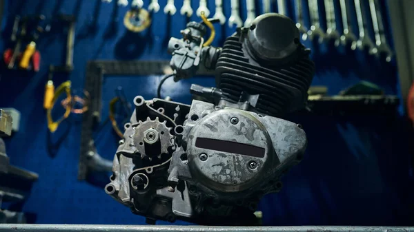 View of a motorcycle engine on a table in a motorcycle workshop. Close-up.
