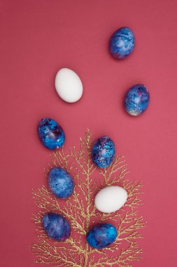 Mutlu Paskalyalar. Paskalya bayramı boyalı yumurtalar ve altın bir ağaç. Burgundy arkaplanı.