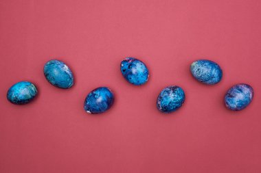 Bordo bir yüzeye mavi boyanmış Paskalya yumurtaları.