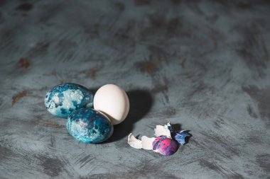 Mavi desenli arka planda Paskalya yumurtası ve yumurta kabuğu..