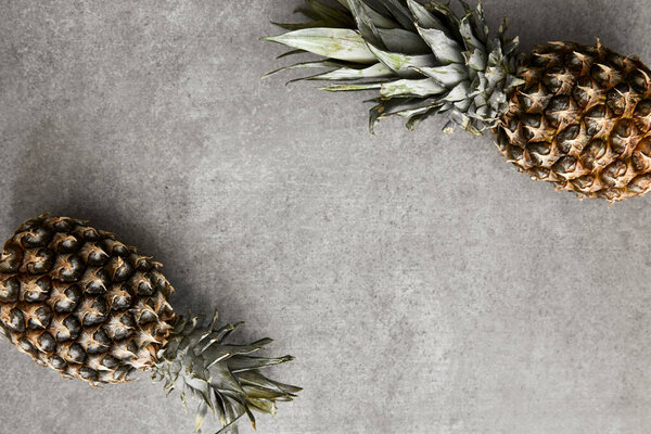 Ripe exotic pineapples on a concrete surface.