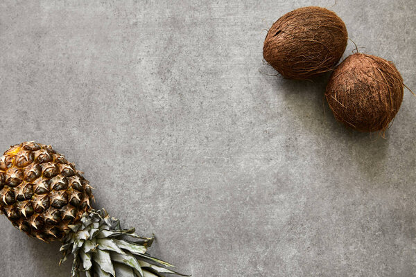 Ананас и кокосы на серой бетонной поверхности
.